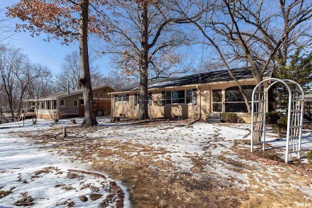 view of front of house with a sunroom and brick siding