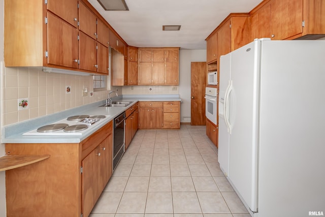 kitchen with brown cabinets, white appliances, and light countertops