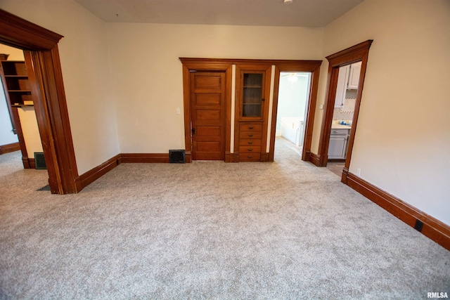 unfurnished bedroom featuring light colored carpet, visible vents, and baseboards