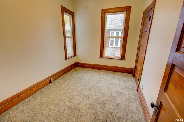 empty room with light colored carpet and baseboards