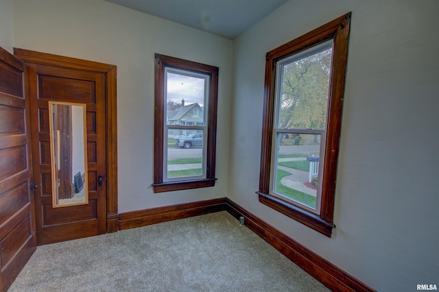 spare room featuring carpet floors and baseboards