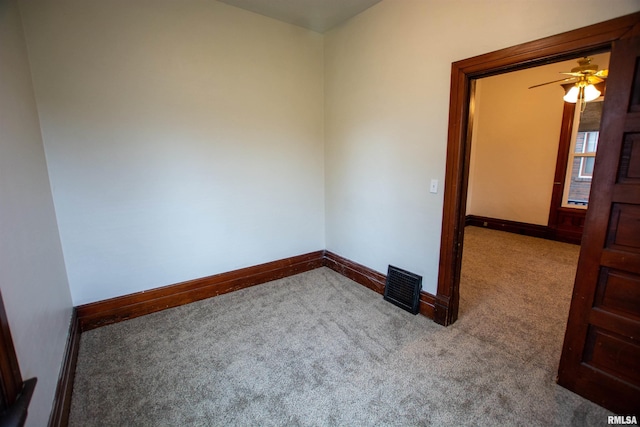 carpeted spare room with visible vents and baseboards