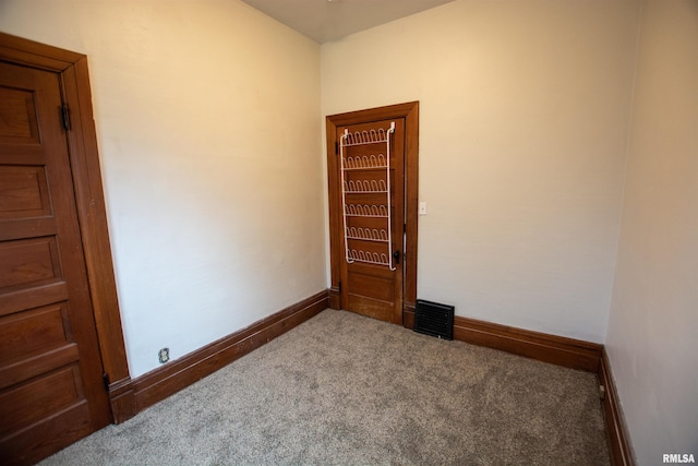 unfurnished room featuring carpet, visible vents, and baseboards