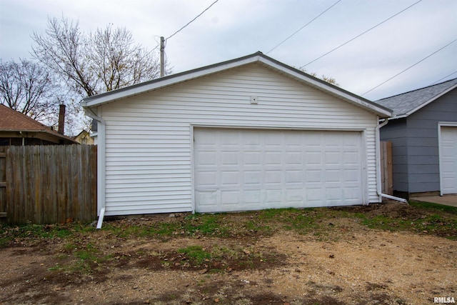 detached garage featuring fence