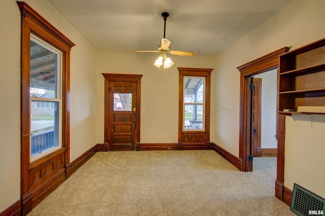 entrance foyer with baseboards, visible vents, and light colored carpet