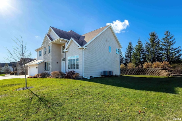 view of side of property with concrete driveway, a lawn, and central air condition unit