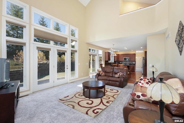 living room with recessed lighting, light carpet, a notable chandelier, visible vents, and baseboards