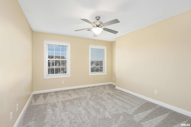 unfurnished room featuring light carpet, ceiling fan, a textured ceiling, and baseboards