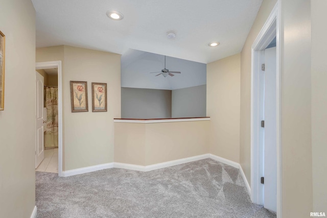 hallway with recessed lighting, light colored carpet, and baseboards