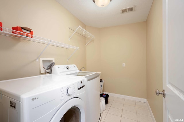 laundry room featuring light tile patterned floors, laundry area, separate washer and dryer, visible vents, and baseboards