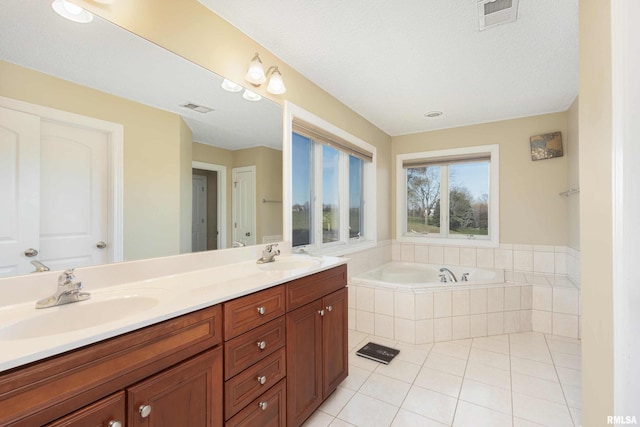 full bath with a garden tub, a sink, and visible vents