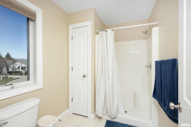 full bath featuring a textured ceiling, a closet, tile patterned flooring, and a stall shower