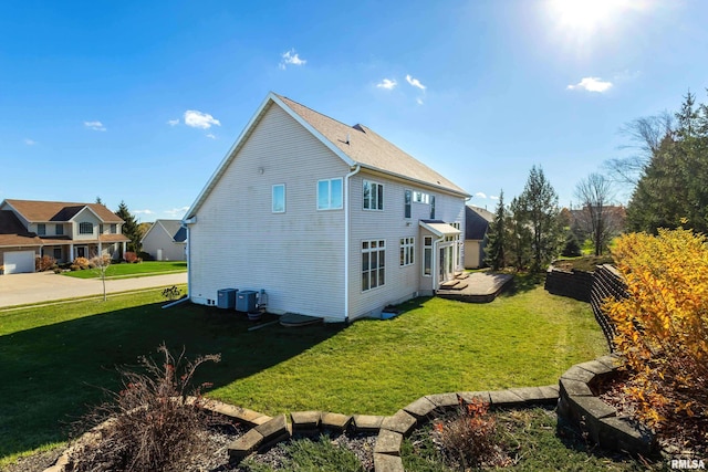 view of property exterior featuring a lawn, fence, and central air condition unit