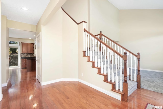 stairs with baseboards and hardwood / wood-style floors