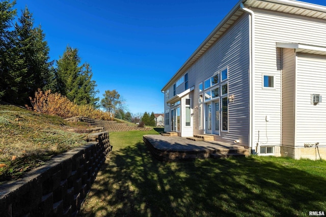 view of property exterior featuring entry steps, a patio, and a lawn