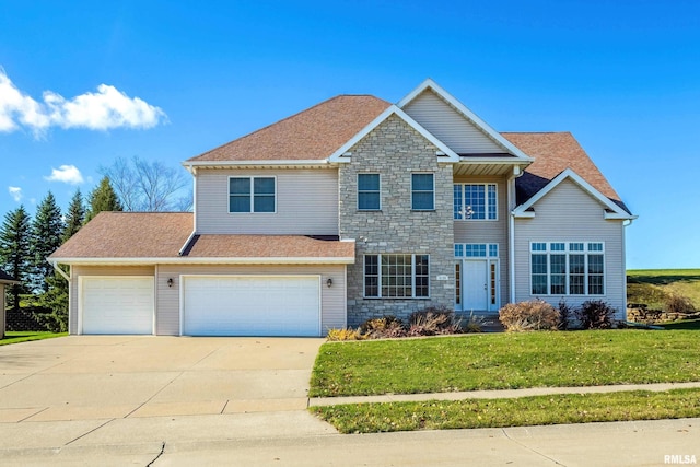 view of front facade featuring a front yard, stone siding, roof with shingles, and driveway