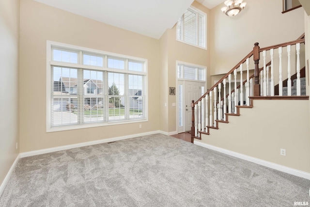 entryway with light carpet, stairway, and baseboards