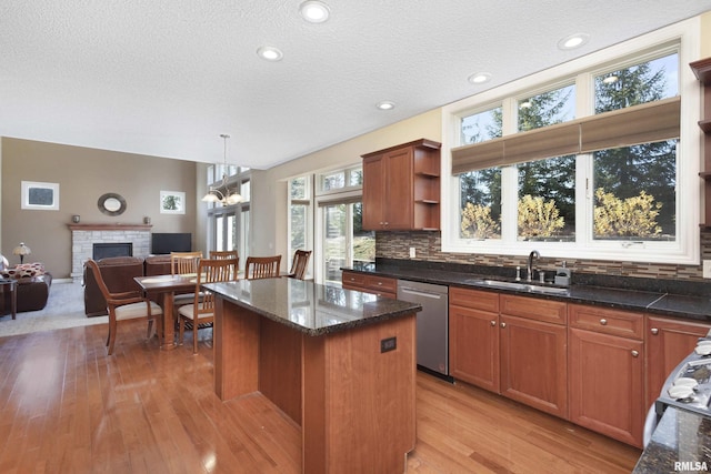 kitchen with a center island, open shelves, brown cabinetry, a sink, and dishwasher