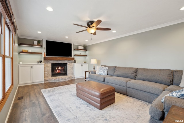 unfurnished living room with visible vents, ornamental molding, a brick fireplace, and light wood-style flooring