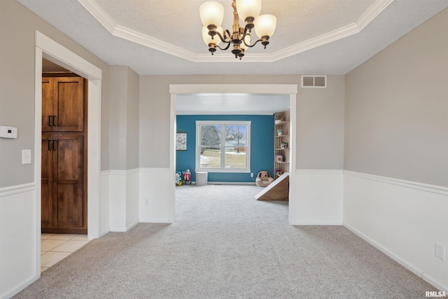 hall with a raised ceiling, visible vents, and light carpet