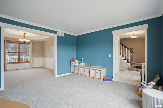 recreation room featuring light carpet, visible vents, a chandelier, and ornamental molding