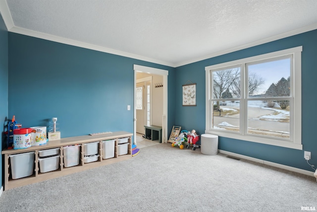 recreation room with a textured ceiling, ornamental molding, baseboards, and light colored carpet