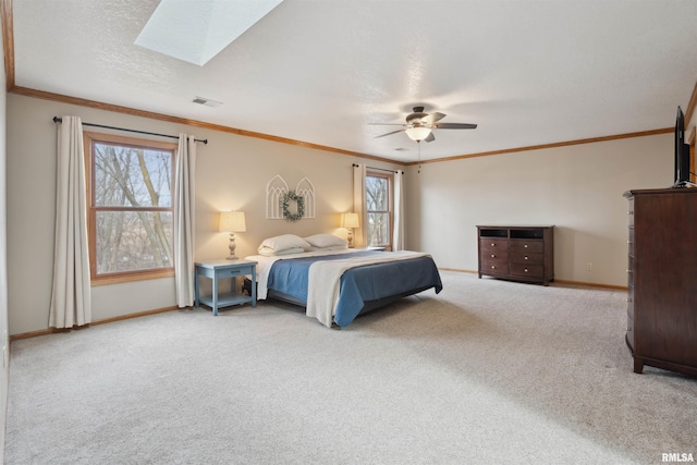 unfurnished bedroom featuring carpet, a skylight, visible vents, and crown molding