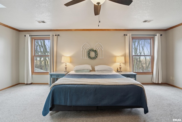 carpeted bedroom featuring ornamental molding, visible vents, and a textured ceiling