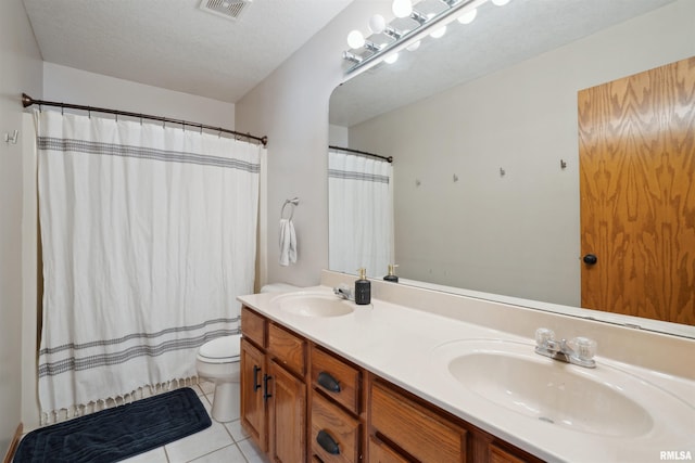 bathroom with double vanity, tile patterned flooring, visible vents, and a sink