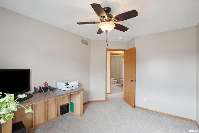 office area with a ceiling fan, visible vents, light carpet, and baseboards