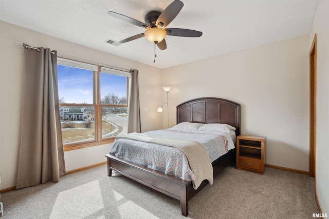 bedroom featuring baseboards, a ceiling fan, visible vents, and light colored carpet