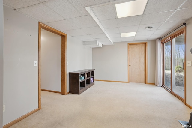 spare room featuring baseboards, a paneled ceiling, visible vents, and light colored carpet