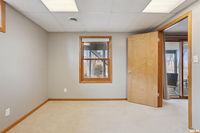 unfurnished room featuring light carpet, baseboards, visible vents, and a paneled ceiling