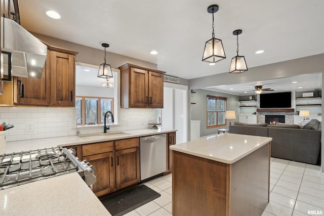 kitchen featuring hanging light fixtures, appliances with stainless steel finishes, light countertops, and a sink