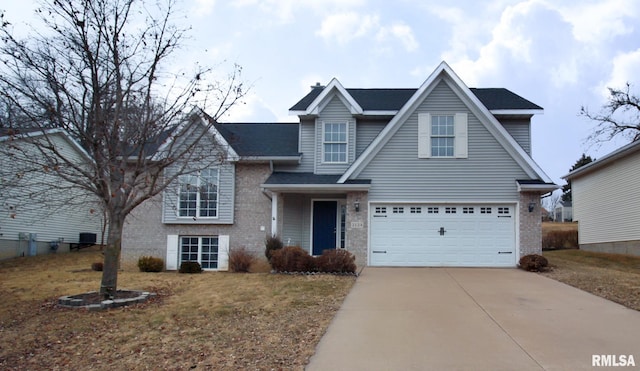 traditional home with a garage, brick siding, and driveway