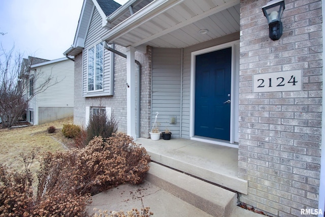 doorway to property with brick siding