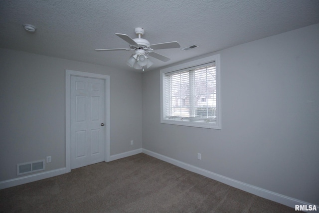 carpeted spare room featuring a textured ceiling, visible vents, and baseboards