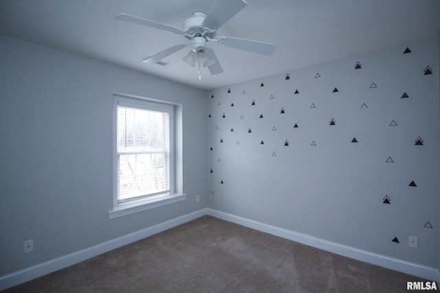 empty room with ceiling fan, carpet, and baseboards