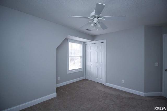 unfurnished bedroom featuring a closet, visible vents, carpet flooring, a textured ceiling, and baseboards