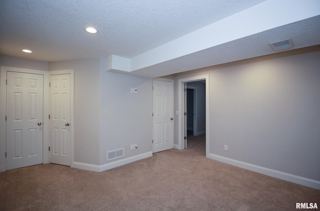 finished basement with carpet floors, baseboards, and visible vents