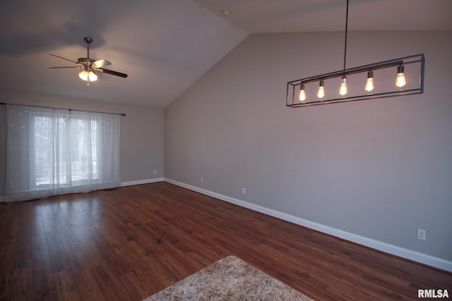 empty room featuring a ceiling fan, lofted ceiling, baseboards, and wood finished floors