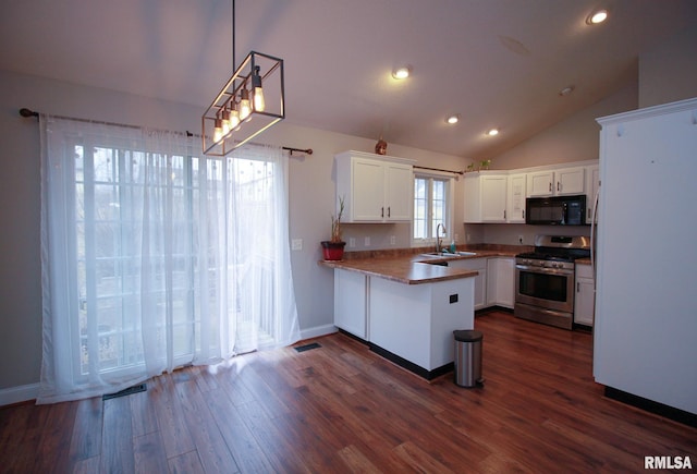 kitchen featuring stainless steel gas stove, a sink, white cabinets, black microwave, and a peninsula