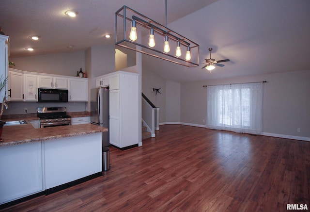 kitchen featuring dark wood-style flooring, appliances with stainless steel finishes, white cabinets, vaulted ceiling, and a sink