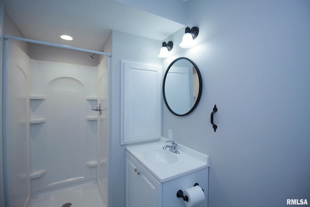 bathroom featuring a stall shower, recessed lighting, and vanity