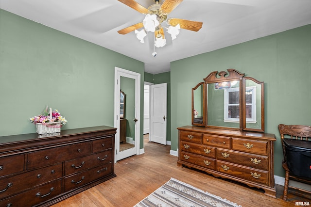 bedroom with light wood-type flooring, ceiling fan, and baseboards