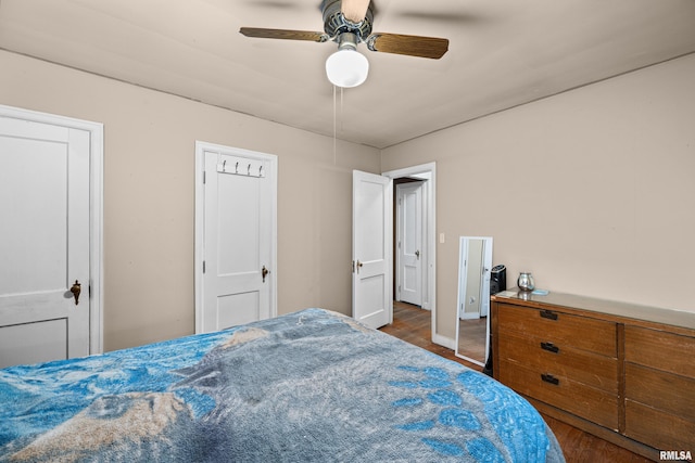 bedroom with ceiling fan, baseboards, and wood finished floors