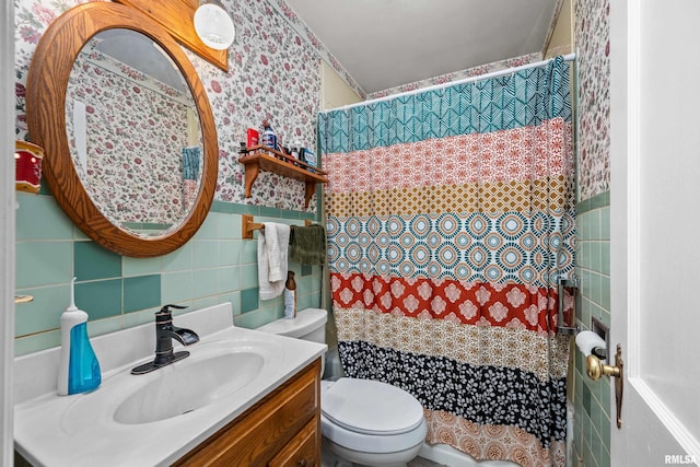 bathroom featuring toilet, a shower with shower curtain, tile walls, and vanity