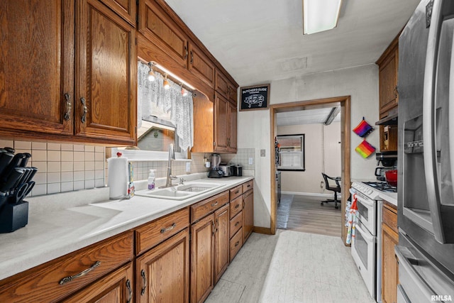 kitchen with light countertops, range with two ovens, a sink, and stainless steel fridge with ice dispenser