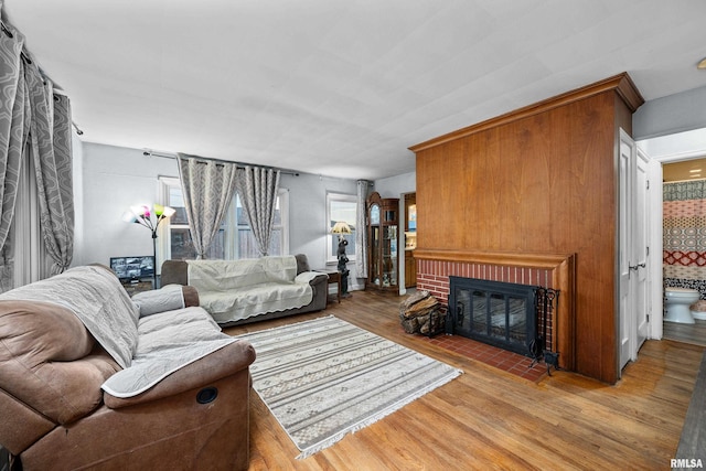 living room featuring light wood-type flooring and a brick fireplace