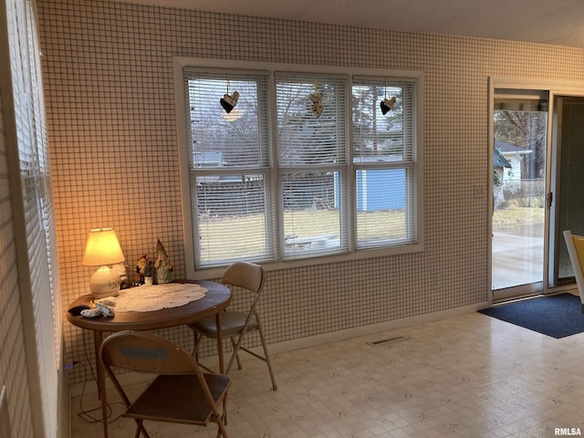 interior space featuring wallpapered walls, tile patterned floors, baseboards, and visible vents